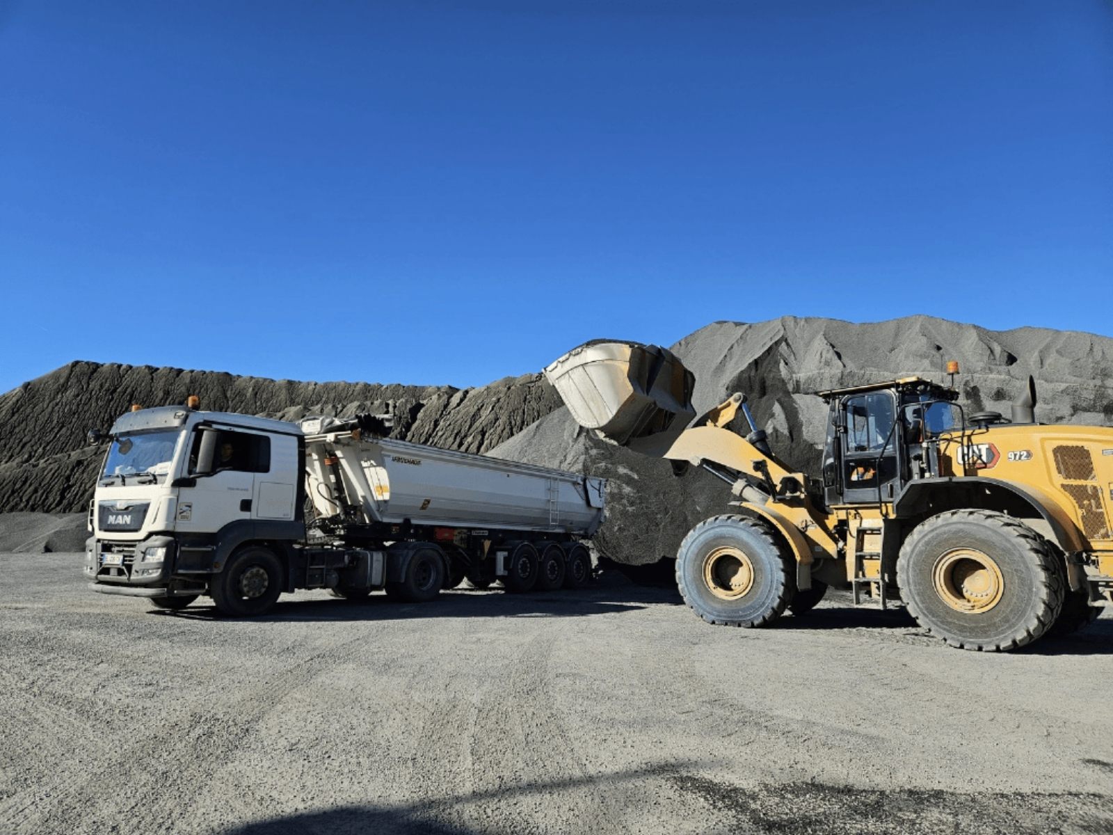 Chargeuse chargeant des graviers sur semi-remorque en carrière à Gorges
